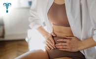 Mujer joven con leve dolor abdominal causado por la transferencia embrionaria